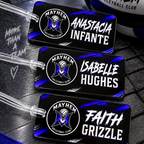 Three custom black volleyball-themed luggage tags with clear plastic loops, featuring the Mayhem Volleyball Club logo and player names Anastacia Infante, Isabella Hughes, and Faith Grizzle. A matching black, white, and blue volleyball is partially visible in the top right corner.