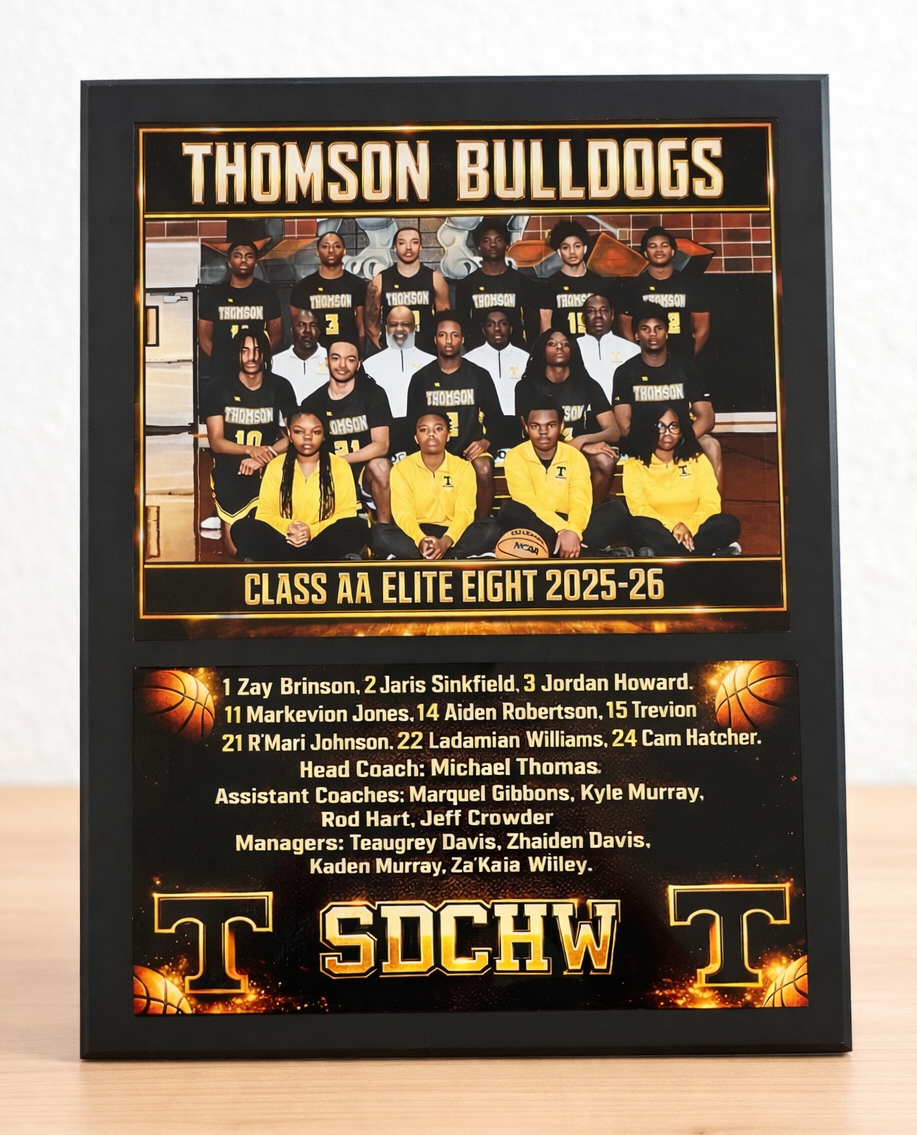 Framed poster of the Thomson Bulldogs Class AA Elite Eight 2025-26 basketball team on a wooden surface.