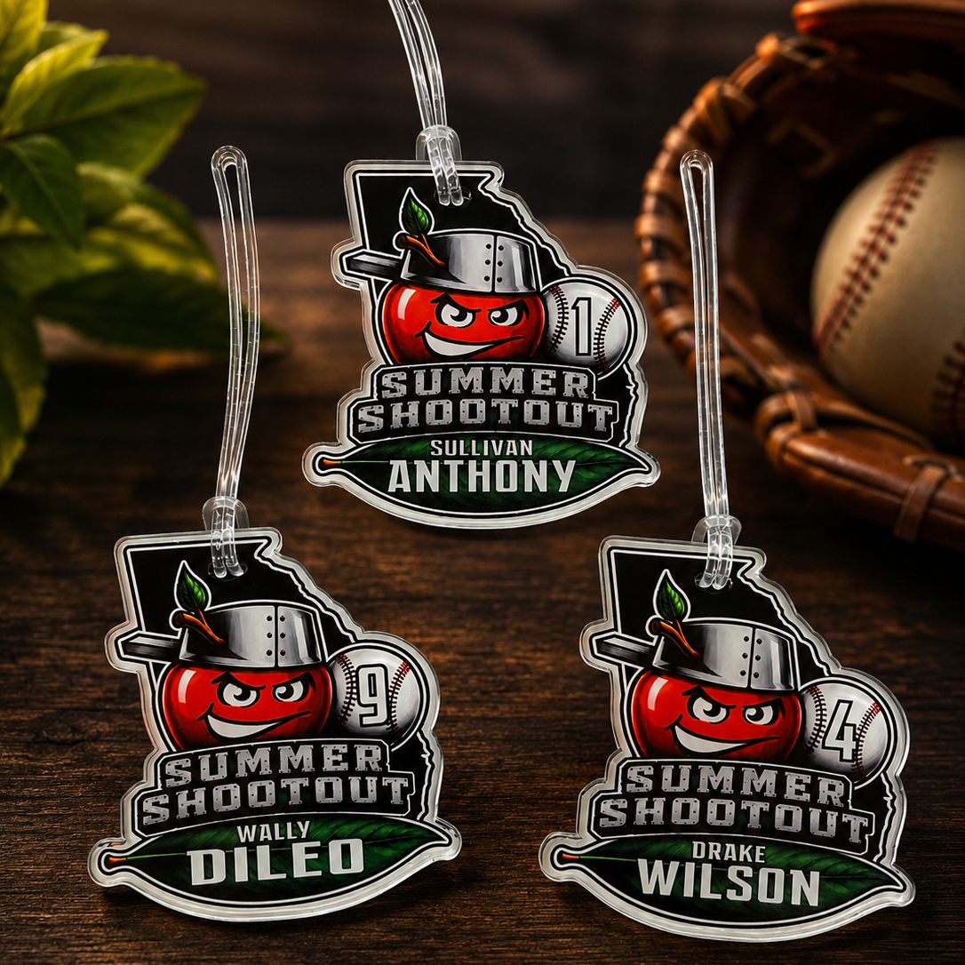 Three personalized 'Summer Shootout' keychains on a wooden surface with a baseball and glove in the background.