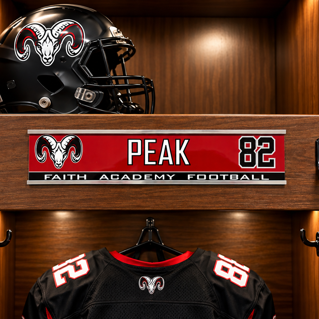 A football helmet and black jersey with red and white accents are displayed inside a wooden locker. A personalized nameplate on the shelf reads PEAK 82 with FAITH ACADEMY FOOTBALL and a ram logo.